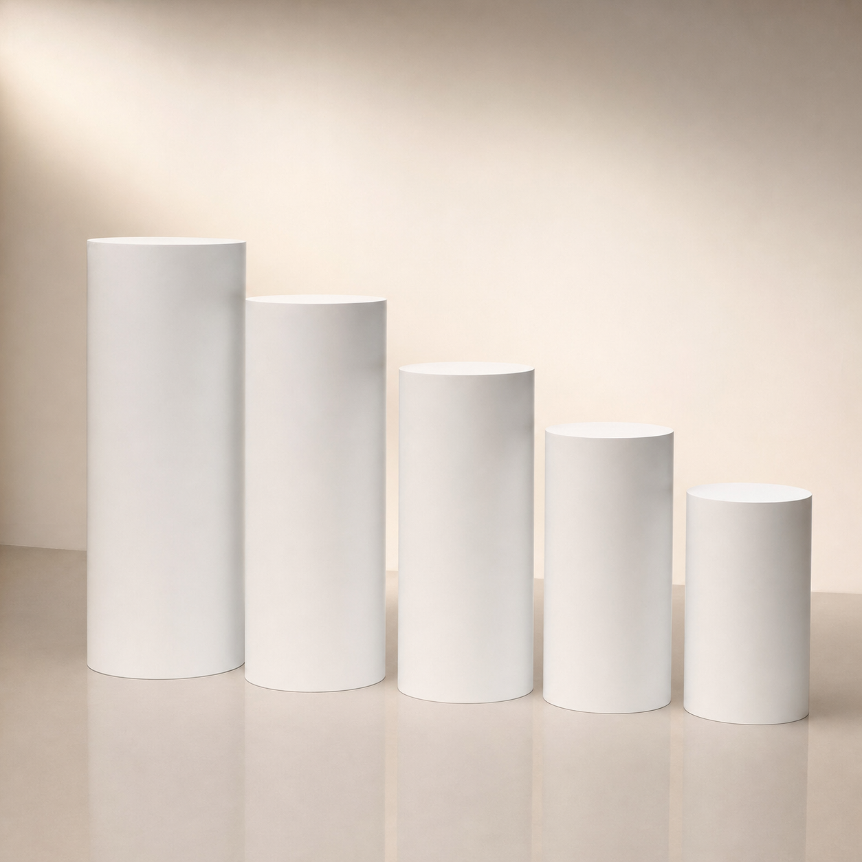 Set of five white cylindrical event pedestals in varying heights